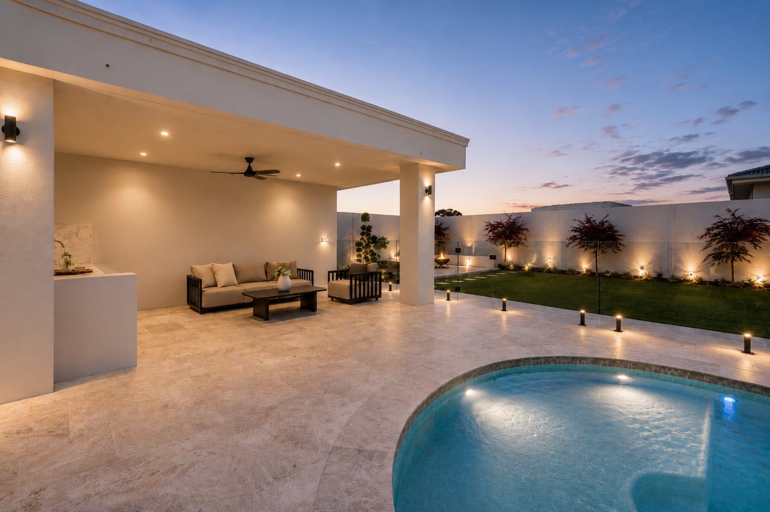 Wide twilight view of pool and double-storey modern home
